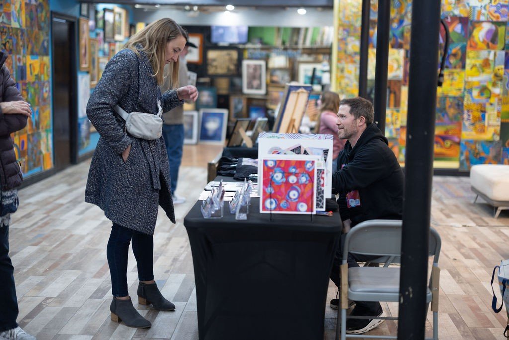 Guests browsing artwork at a gallery member show